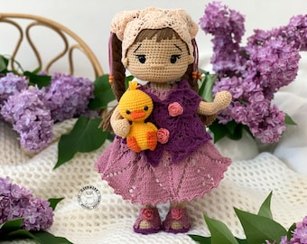 LUCY la jolie poupée vêtue d'une belle blouse en tricot et de chaussures avec des petites roses décoratives au crochet et son petit canard jaune