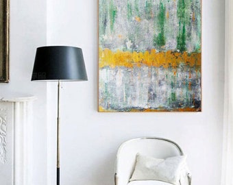 May include: Abstract art painting with a wooden frame. The artwork features a textured surface with vertical green and orange brushstrokes over a gray and white background. A gold horizontal band is in the center. The painting hangs on a white wall.