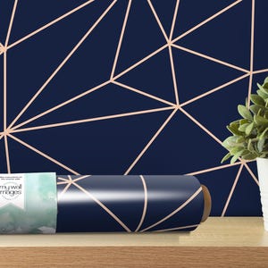 a plant in a white vase next to a blue wall