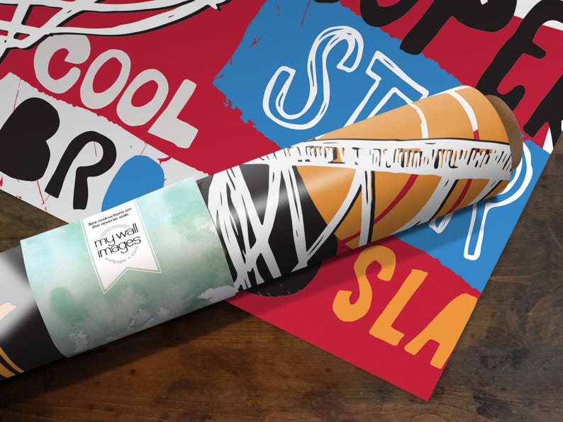 A roll of paper with various colorful and abstract designs printed on it, placed on a wooden surface.