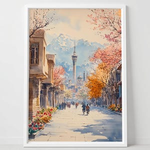 Pode incluir: Pintura em aquarela de uma cena de rua da cidade com uma torre alta ao fundo. A obra apresenta edifícios, árvores com folhas rosa e laranja e pessoas andando e andando de bicicleta na rua. A pintura é emoldurada em uma moldura branca.