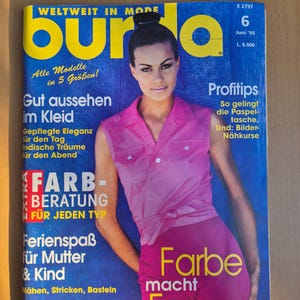 Puede incluir: Una portada de revista vintage con la palabra "burda" en letras amarillas grandes. La portada presenta a una mujer con un atuendo rosa y texto en alemán, incluyendo "Farbe macht Furore" y "WELTWEIT IN MODE".