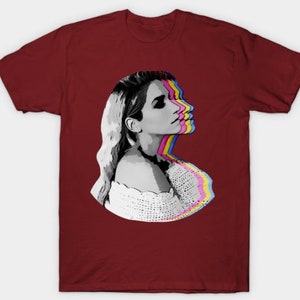 May include: A maroon t-shirt with a graphic of a woman's face with a colorful, layered effect. The woman is looking to the right and has blonde hair.