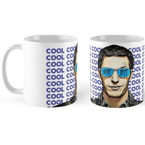 May include: White ceramic mug with a blue and white design. The mug features a cartoon image of a man wearing sunglasses with the text "NICE BUTT" on the lenses. The text "COOL COOL COOL" is repeated on the mug.