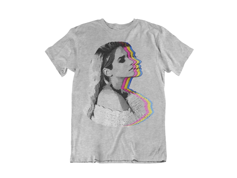 May include: A grey t-shirt with a graphic print of a woman's face in a layered, colorful, psychedelic style.