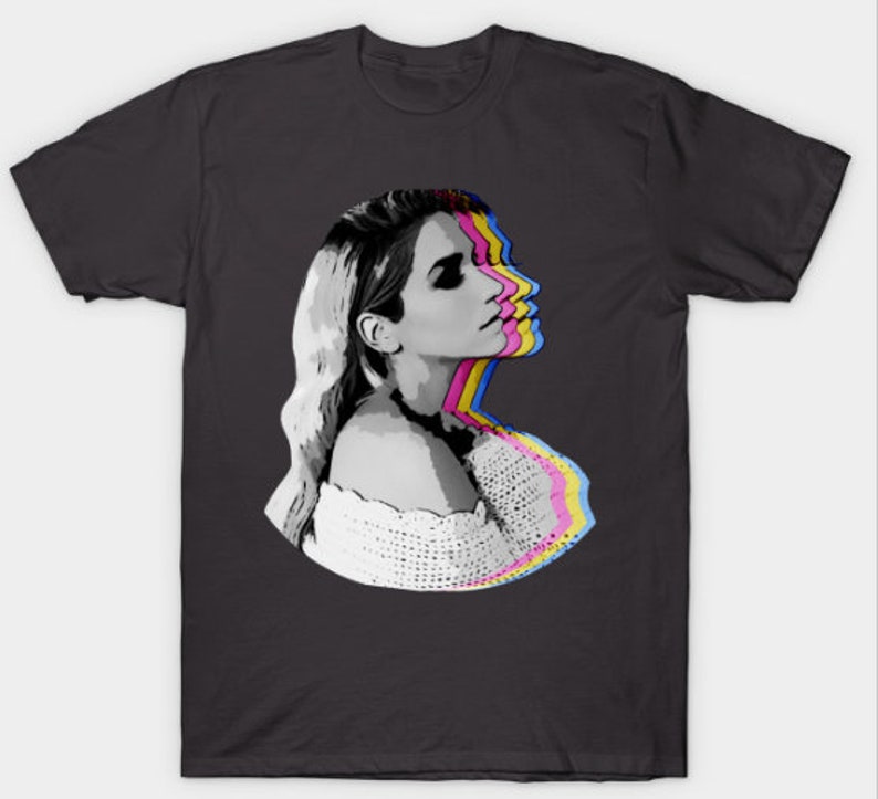 May include: A black and white graphic t-shirt design featuring a woman's face with a layered, colorful effect. The woman is looking to the right and has long blonde hair. She is wearing a white crocheted top.
