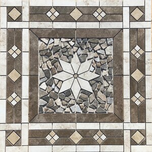 May include: Square decorative tile with a mosaic center featuring a starburst design. The tile has a border of brown, beige, and white geometric patterns. The center is surrounded by small, irregularly shaped stones in shades of gray and brown.