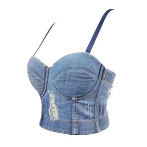 May include: A light blue denim corset top with adjustable straps and distressed detailing.