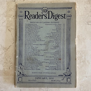 Könnte beinhalten: Titelseite des Reader's Digest Magazins vom Januar 1930. Das Cover ist ein gedämpftes Blau-Grau mit dem Titel der Zeitschrift in fetten, dunkelblauen Buchstaben. Das Cover listet interessante Artikel und zeigt dekorative Säulen und Figuren.