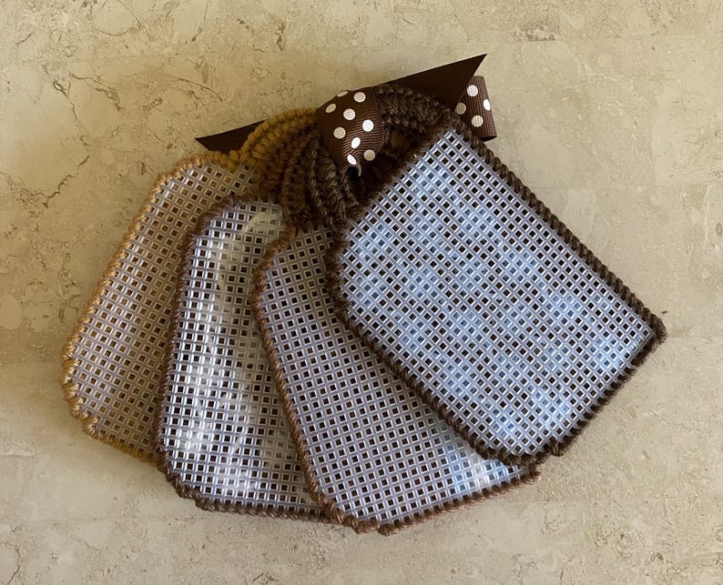 Pu&ograve; includere: Cinque etichette in tela plastica marrone e bianca con bordatura marrone. Le etichette sono vuote e pronte per essere ricamate. Un nastro marrone con pois bianchi &egrave; attaccato alla parte superiore delle etichette.