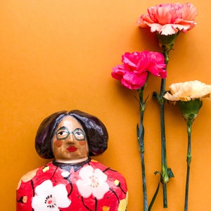 Statuetta in ceramica a forma di donna con vestito rosso a fiori