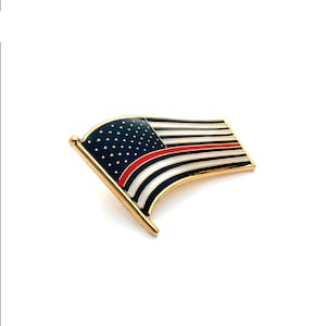 May include: A gold-colored pin with a red, white, and blue American flag design. The flag has a thin red stripe across the middle, representing the "thin red line" of firefighters.