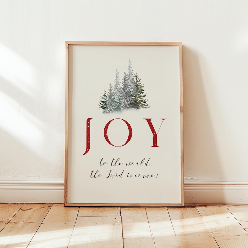 K&ouml;nnte beinhalten: Gerahmter Kunstdruck mit hellem Hintergrund. Das Wort "JOY" steht in gro&szlig;en, roten Buchstaben. Darunter steht der Text "to the world, the Lord is come!" Oben befindet sich ein Aquarellbild von Nadelb&auml;umen.