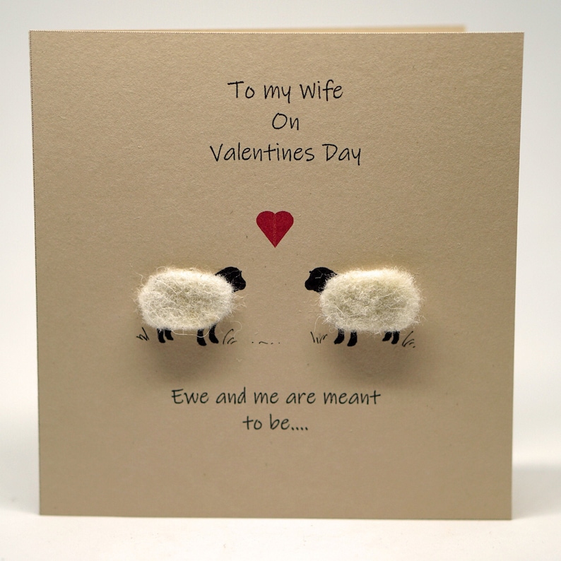 May include: A Valentine's Day card with a red heart and two white sheep with black faces. The card reads "To my wife on Valentine's Day" and "Ewe and me are meant to be..."