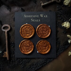 May include: Four gold adhesive wax seals with the text "Thank You" in a decorative font. The seals are displayed on a black card with the text "Adhesive Wax Seals".