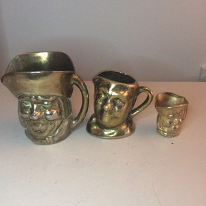 Set of 3 graduated brass Toby Jugs