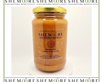 Puede incluir: Un tarro de vidrio de gel de alga marina con tapa dorada. La etiqueta dice "SHEMOORE HEAL THYSELF NATURALLY Sea Moss Gel Elderberry, Turmeric & Ginger".
