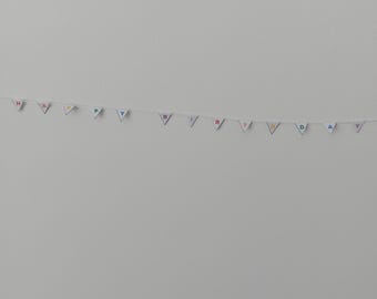 May include: A white wall with a colorful banner that reads "Happy Birthday" hanging from it.