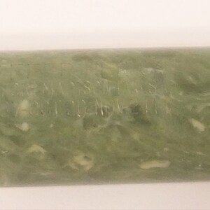 May include: A green and white marbled pen with the inscription "MADE IN USA  PAT 2024714" on the side.