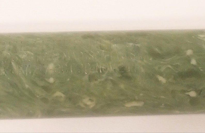 May include: A green and white marbled pen with the inscription "MADE IN USA  PAT 2024714" on the side.