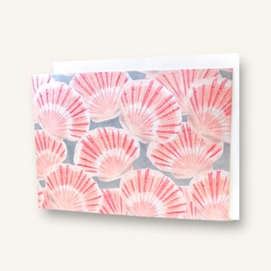May include: A close-up of a pattern of pink and white seashells on a light blue background.