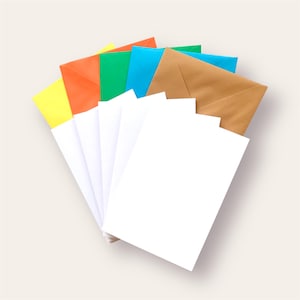 May include: A selection of colourful envelopes and white paper. The envelopes are in yellow, orange, green, blue, and brown. The white paper is stacked in front of the envelopes. The items are arranged in a fan shape.