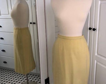Beautifully tailored wool skirt with kick pleat detailing in soft butter yellow