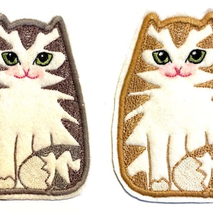 Peut inclure: Deux patchs brodés thermocollants représentant un chat blanc avec des rayures brunes et orange. Le chat est assis, la queue enroulée autour de ses pattes. Les patchs mesurent environ 7,5 cm de haut.