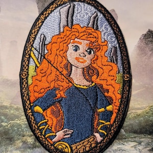 Może przedstawiać: Haftowana naszywka przedstawiająca postać z kreskówki z długimi, kręconymi, pomarańczowymi włosami, ubraną w niebieską sukienkę. Naszywka ma owalny kształt z ozdobną obwódką. Tło przedstawia krajobraz ze strukturami kamiennymi.