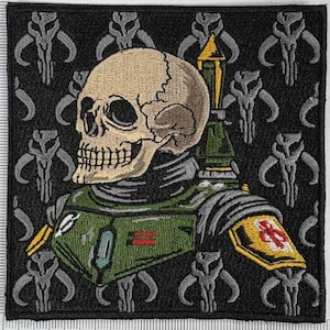Puede incluir: Parche bordado con una calavera que lleva una armadura verde y gris con detalles amarillos. El fondo negro está adornado con símbolos de calaveras mandalorianas grises. El parche tiene forma cuadrada.