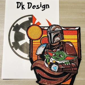 May include: Embroidered patch featuring a brown-clad Mandalorian holding a small green alien, known as "The Child" or "Baby Yoda", against a backdrop of a sunset and a stylized Imperial symbol. The patch is surrounded by a yellow and orange border.
