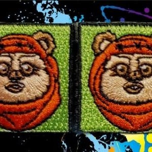 Pode incluir: Dois patches bordados para passar a ferro com um personagem castanho e laranja com uma expressão de surpresa. O personagem está sobre um fundo verde.