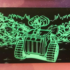 Può includere: Una carta rettangolare nera con un'illustrazione a linee verde neon brillante del robot Wall-E. Il personaggio è posizionato al centro, circondato da cumuli di rottami e detriti, con la sagoma dello skyline di una città sullo sfondo.