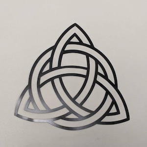 May include: A black metal Celtic knot design in the shape of a triangle.