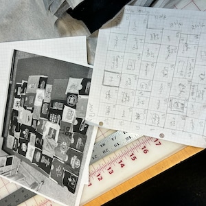 以下が含まれることがあります： 壁にTシャツの寄せ集めで覆われた、白黒の写真。Tシャツはすべて異なる色で、さまざまなデザインとロゴがあります。写真は少し角度をつけて撮影されており、壁は木製の床のある部屋にあります。