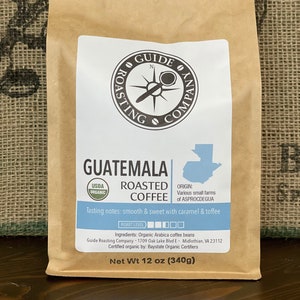 May include: A brown paper bag with a white label that says "Guatemala Roasted Coffee" with a compass logo and the text "Guide Roasting Company". The bag is labeled with USDA Organic and has a net weight of 12 oz (340g).