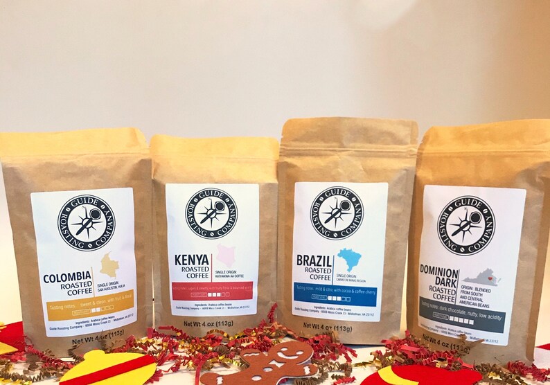 May include: Four brown paper bags of coffee beans from the Guide Roasting Company. The bags are labeled with the origin of the beans: Colombia, Kenya, Brazil, and Dominion Dark Roasted Coffee. Each bag has a net weight of 4 ounces (113 grams).