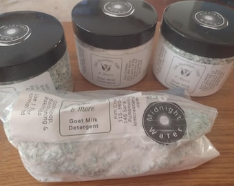May include: Three jars and a bag of Goat Milk Detergent. The jars have black lids with a white label and the text "Midnight Water". The bag has a clear plastic with a white label that reads "Goat Milk Detergent".