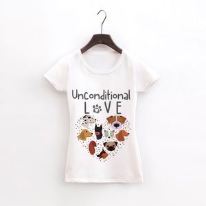 May include: White t-shirt with a grey graphic of a heart made of dog faces and the text "Unconditional LOVE" with a paw print in the O.