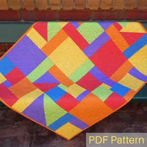 May include: A colourful quilt pattern featuring geometric shapes in shades of red, orange, yellow, green, blue, and purple. The pattern is made up of squares and rectangles, and the colours are arranged in a modern and abstract design. The quilt is displayed on a wooden surface with a brick wall in the background. The text "PDF Pattern" is visible at the bottom of the image.