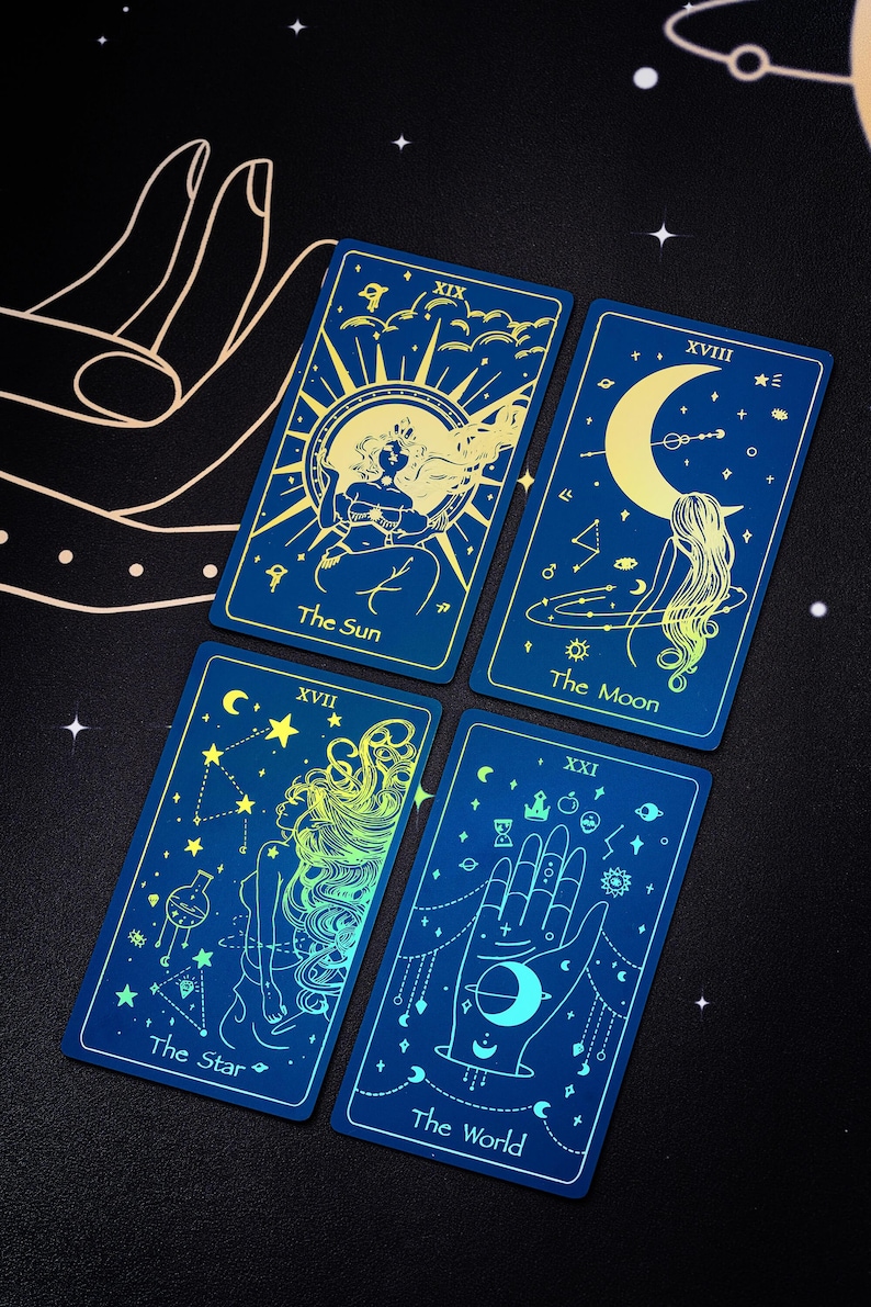 Pode incluir: Quatro cartas de tar&ocirc; com fundos azuis e detalhes em ouro. As cartas s&atilde;o O Sol, A Lua, A Estrela e O Mundo. Cada carta apresenta um design celestial e uma mulher.