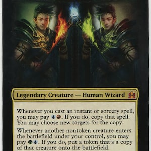 May include: A Magic: The Gathering card featuring Riku of Two Reflections, a legendary creature with a blue, black, and green mana cost. The card art depicts a human wizard with three reflections, each representing a different color of magic. The card text reads "Whenever you cast an instant or sorcery spell, you may pay . If you do, copy that spell. You may choose new targets for the copy. Whenever another nontoken creature enters the battlefield under your control, you may pay . If you do, put a token that's a copy of that creature onto the battlefield." The card has a power and toughness of 2/2.