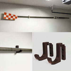 Peut inclure: Une rame en bois avec une pale à damier orange et blanc est fixée au mur. La rame est maintenue par deux supports en bois. Deux crochets muraux bruns en forme de J sont également présentés. La rame mesure environ 240 cm.