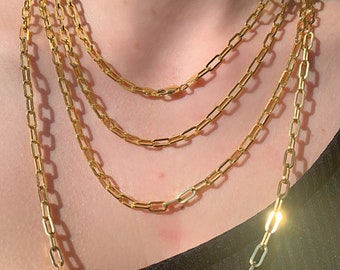 Könnte beinhalten: Eine mehrreihige goldene Kettenkette mit mehreren Strängen aus miteinander verbundenen quadratischen Kettengliedern.