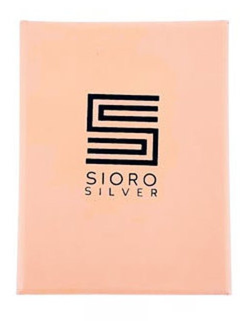 May include: A peach-colored box with a black logo. The logo is a stylized letter "S" with the text "Sioro Silver" below it.