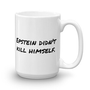 Może przedstawiać: Biały ceramiczny kubek do kawy z czarnym tekstem, który brzmi "EPSTEIN DIDN'T KILL HIMSELF."
