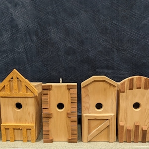 Può includere: Sette casette per uccelli in legno con diversi design e stili. Ogni casetta ha una piccola apertura per consentire agli uccelli di entrare. Le casette sono tutte in legno naturale e hanno un aspetto rustico.