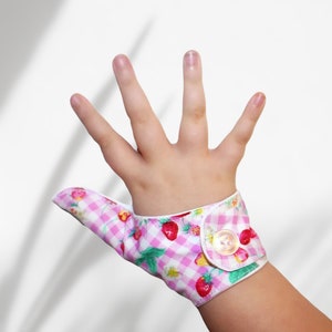 Stop thumb sucking with our pretty thumb guard. Fabric thumb glove has strawberry and cherry theme. May be pulled off by babies & toddlers.