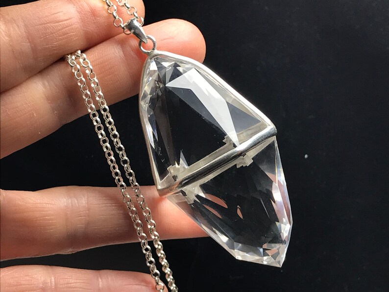 May include: A clear quartz crystal pendant with a silver setting, hanging from a silver chain.
