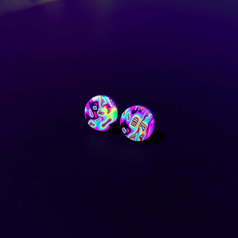 May include: A pair of iridescent earrings with a swirling pattern in shades of pink, blue, green, and yellow.